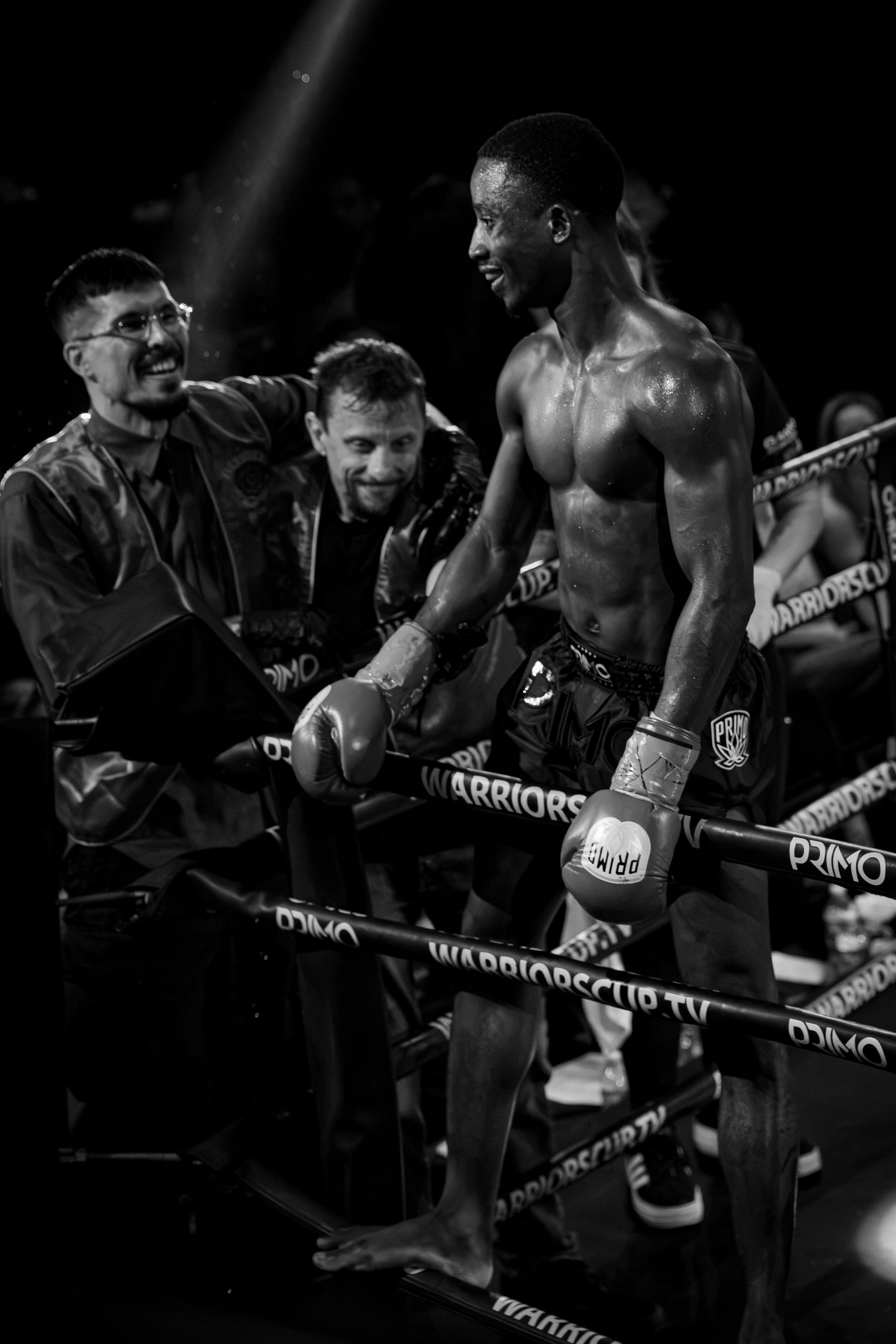 A fighter standing at the ropes with his corner after the bell