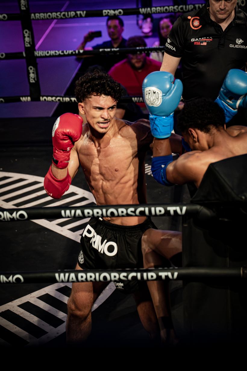 Kick landing in the ring under the Warriors Cup lights