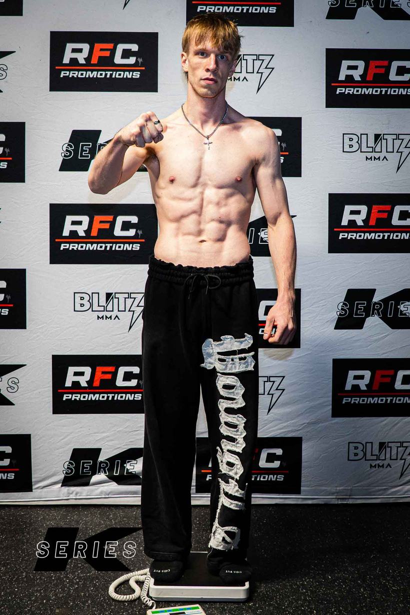 Fighter posing shirtless at the weigh in scale