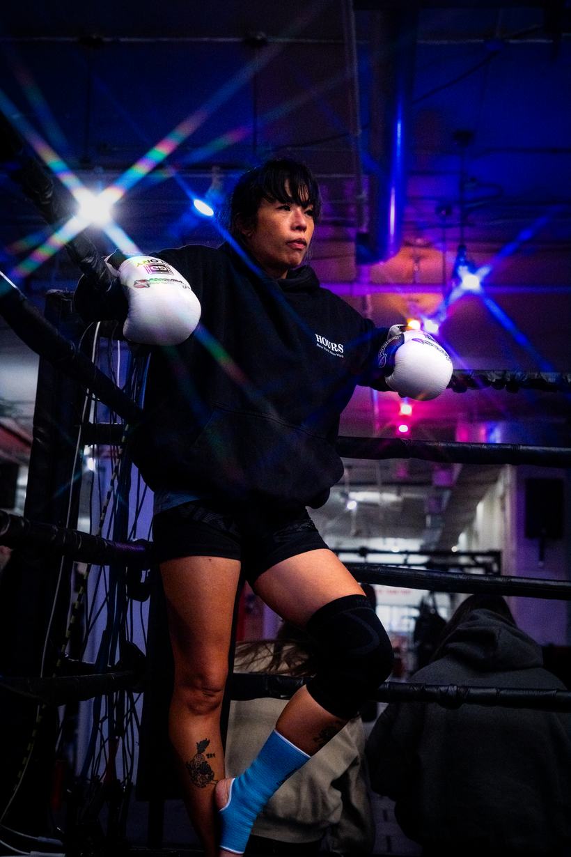 Fighter resting on the ring apron, wraps and gloves on