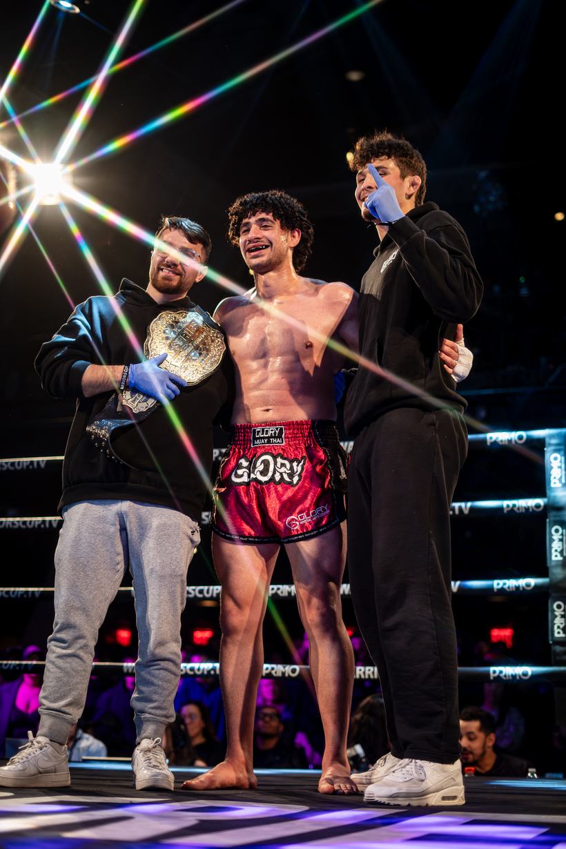 Champion holding a title belt as the lights flare