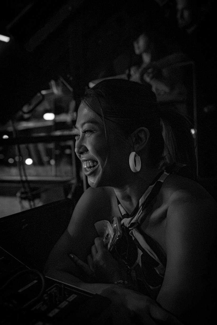 Fighter laughing candidly backstage, sunglasses in hand