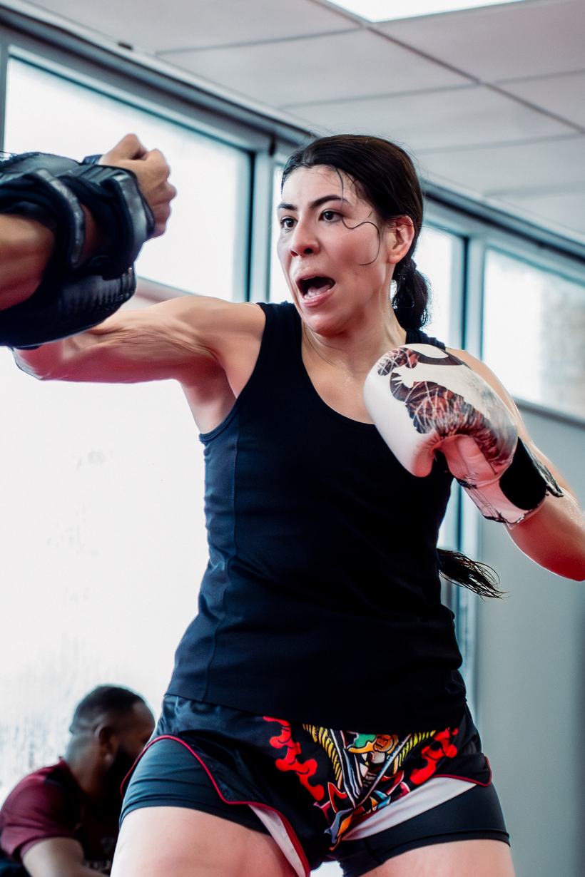 Fighter punching straight down the lens in the gym