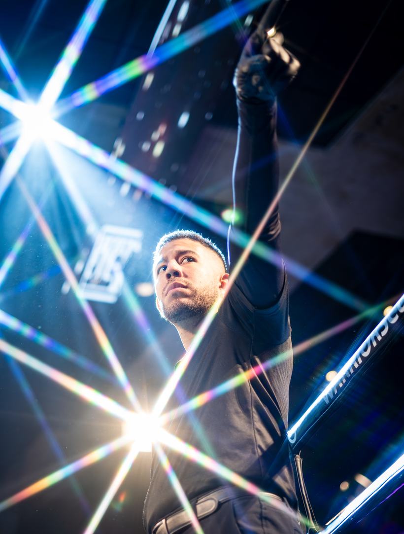 Fighter's fist raised through a wash of laser light