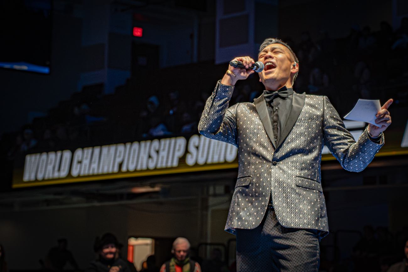 Announcer in a sequinned tuxedo calling the card