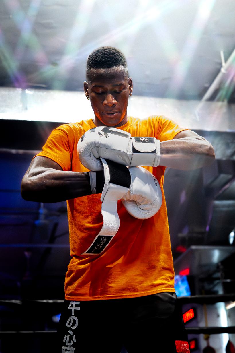Fighter adjusting his gloves before stepping out under the lights