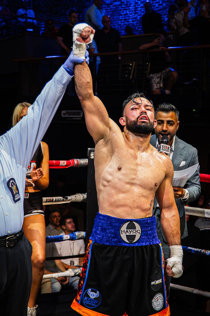 Singer performing the anthem, laser lights crossing the ring