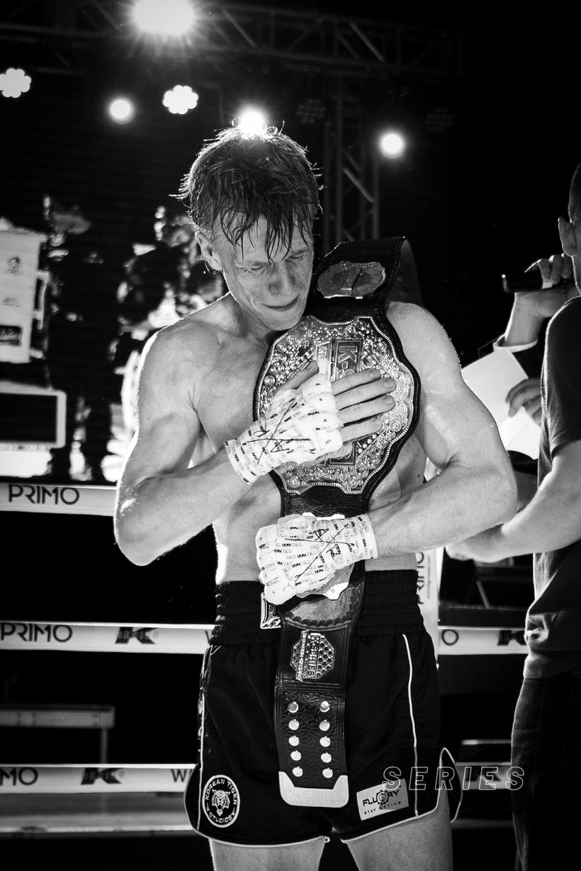 Sweat soaked champion clutching his belt with both hands