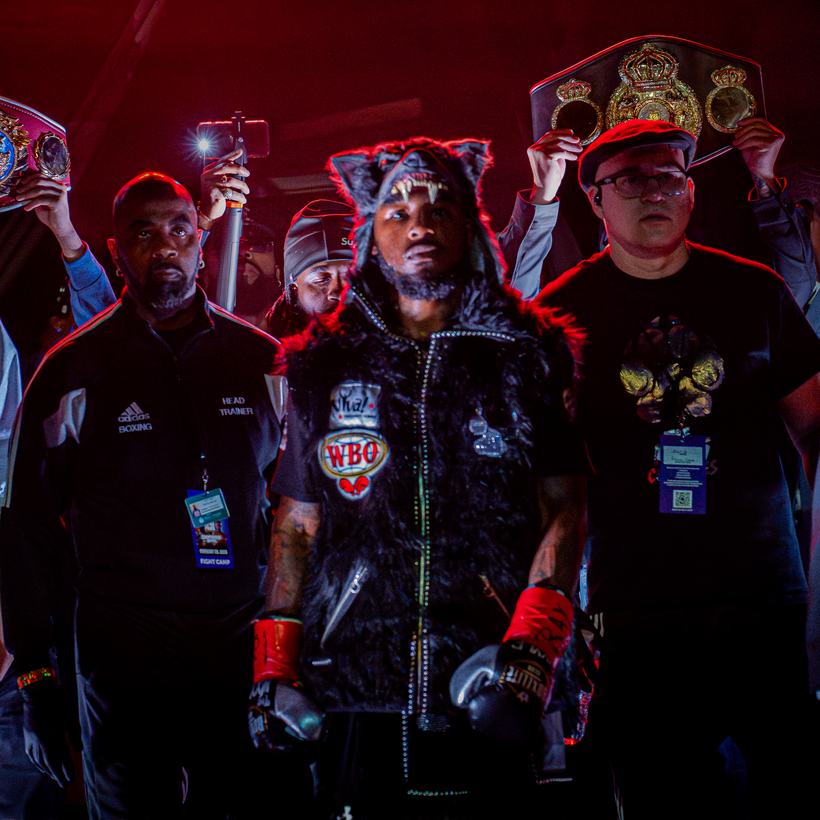 Fighter walking out with his belts held up behind him