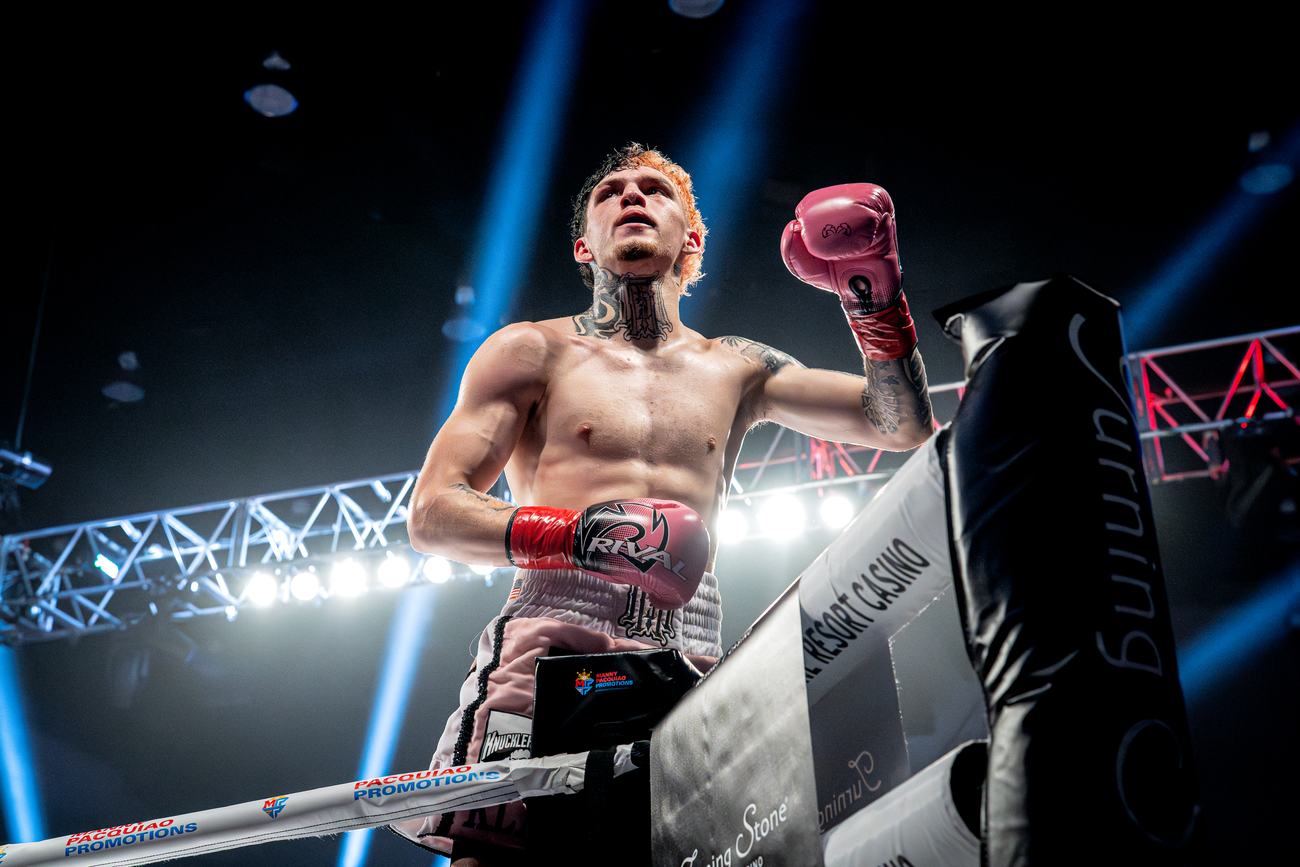 Fighter's pink glove raised beside the Turning Stone corner pad