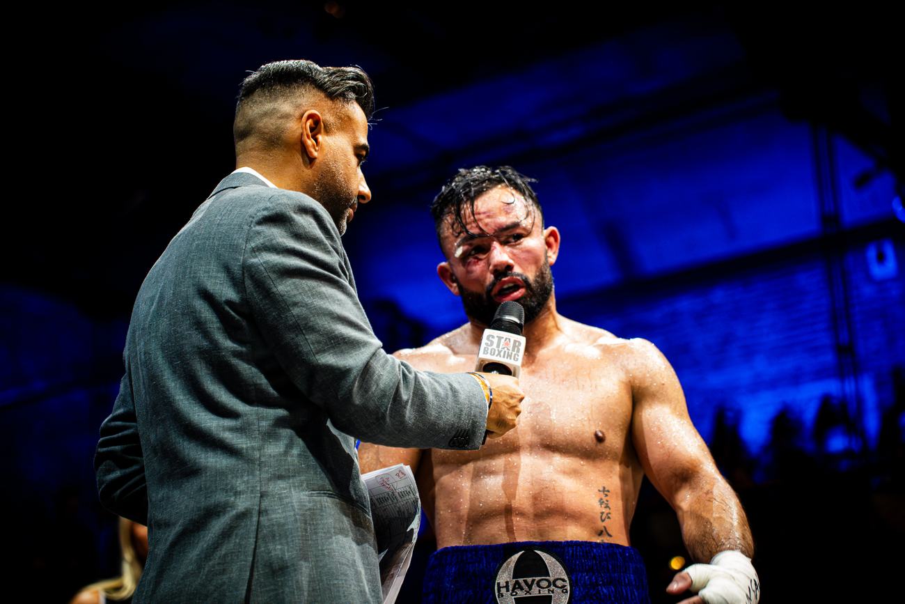 Bloodied boxer answering questions in the ring