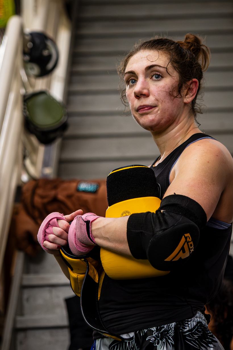 Fighter resting between rounds, wraps and pads still on