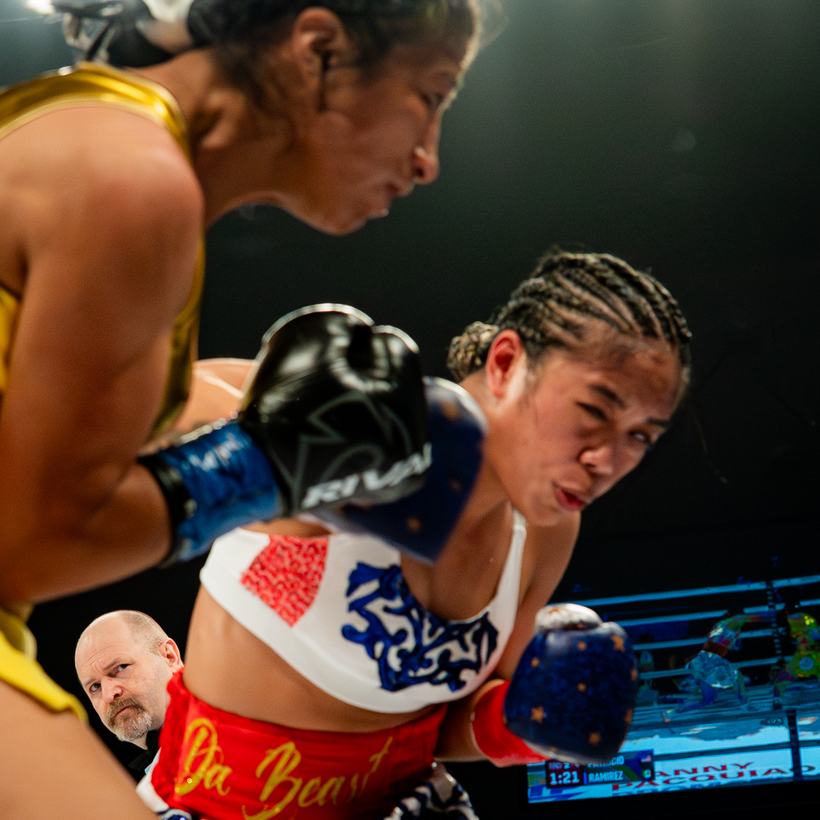Two women boxers exchanging punches low and close
