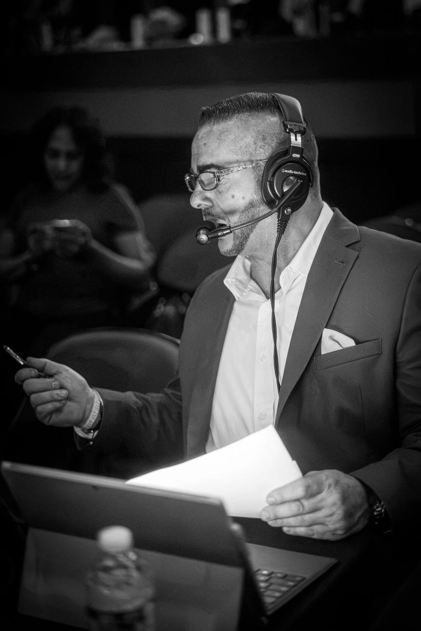 Commentator on headset reading from his notes