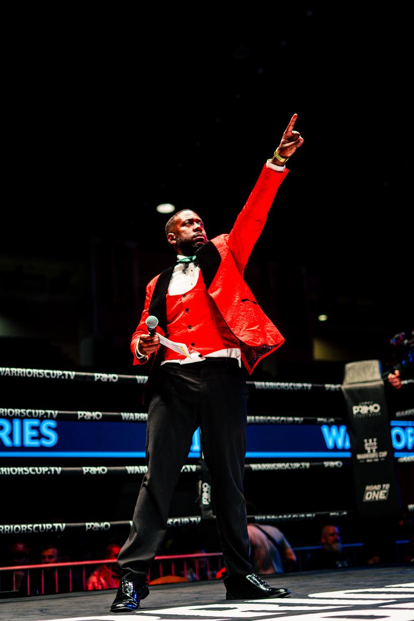 Ring announcer in a red jacket calling the fight to the crowd