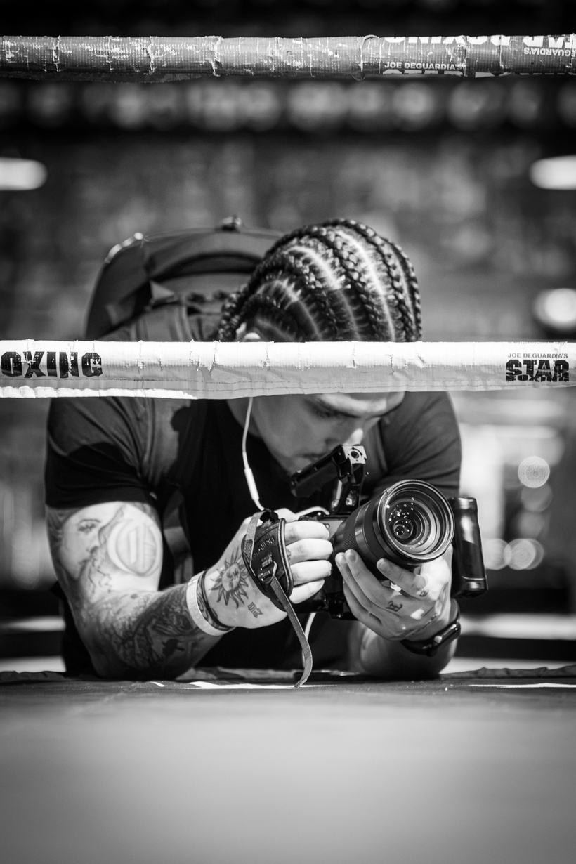 Photographer lying flat on the apron to shoot the ring