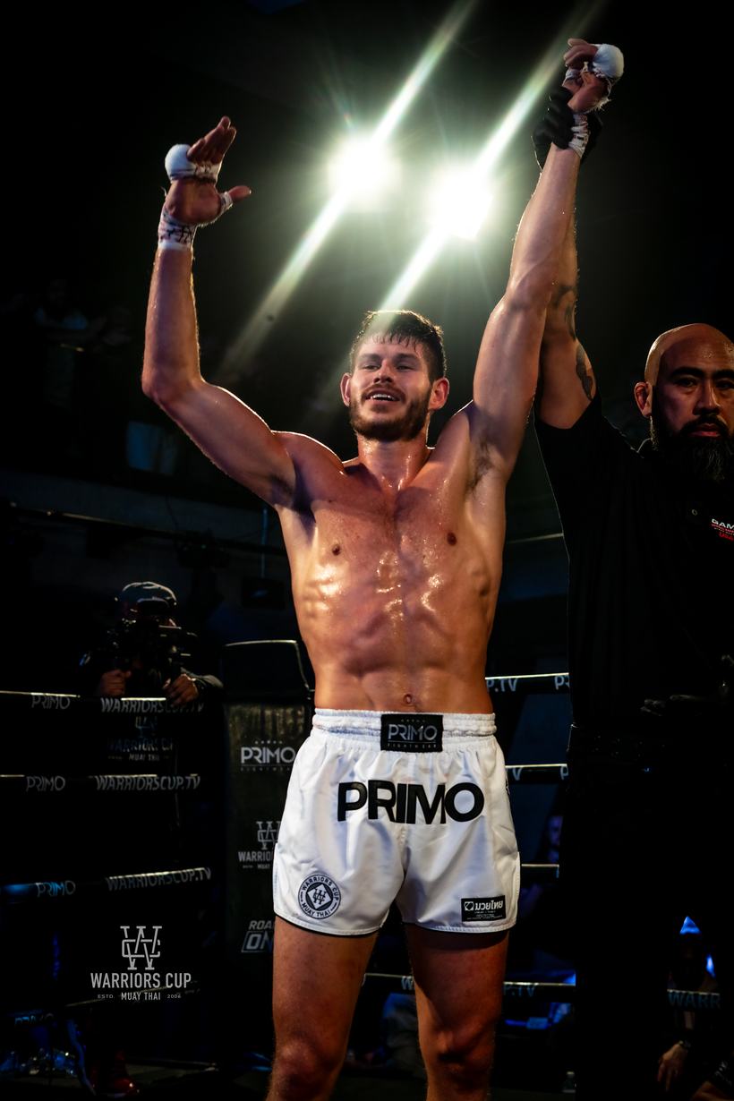 Fighter with both arms raised as the win is called