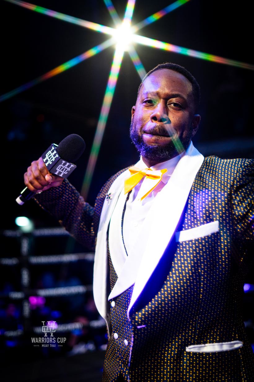 Announcer in a sequinned jacket working the microphone