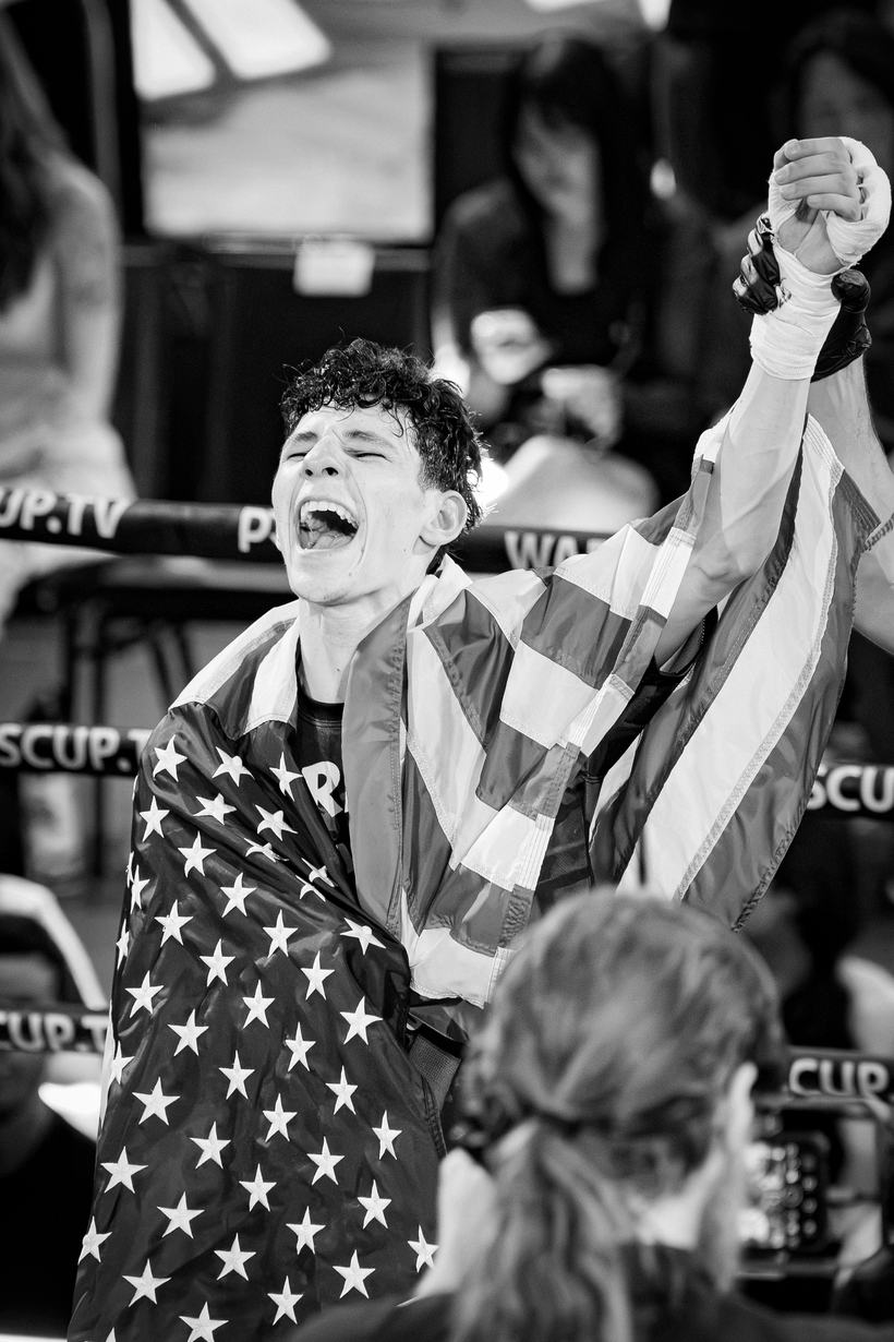 Fighter wrapped in a flag, shouting after the win