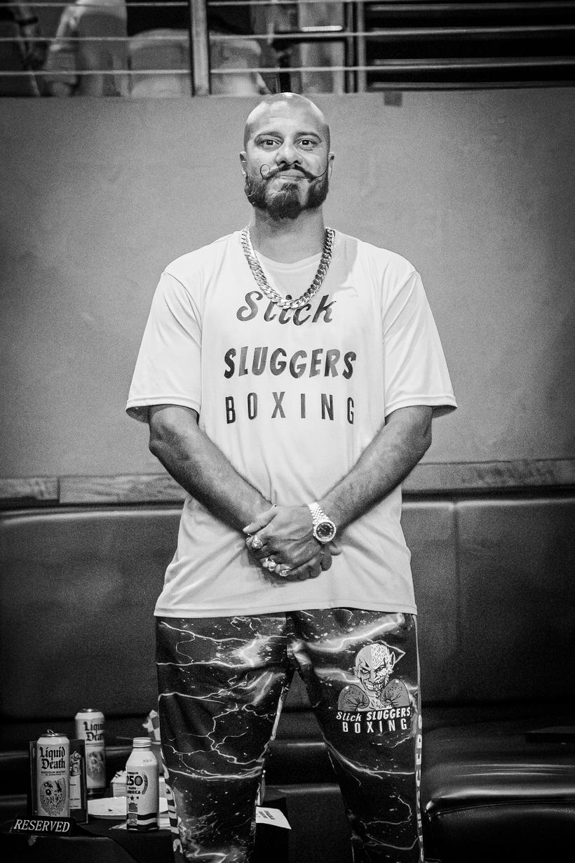 Referee raising the winning boxer's hand at the weigh in card