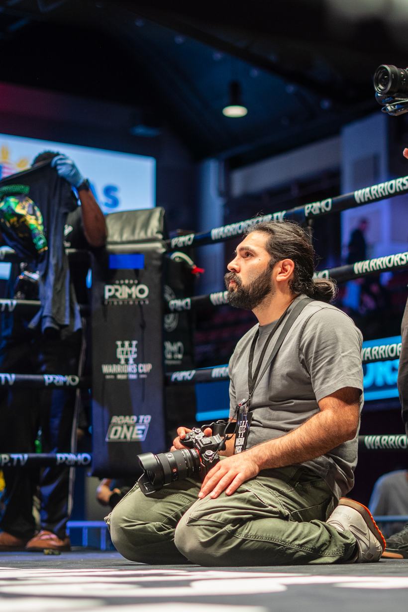 Photographer kneeling at the ring apron between rounds