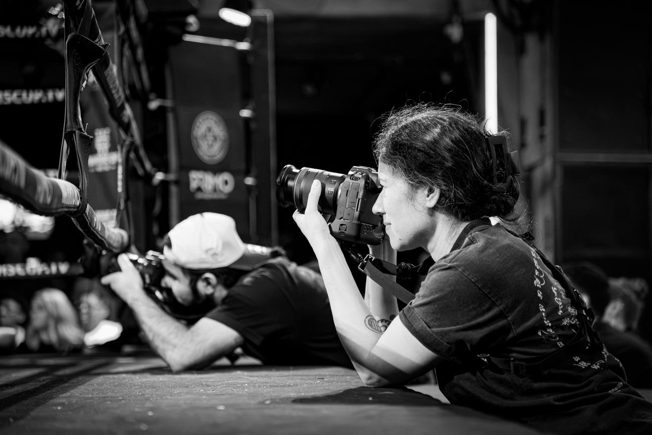Two photographers working from the floor at ringside