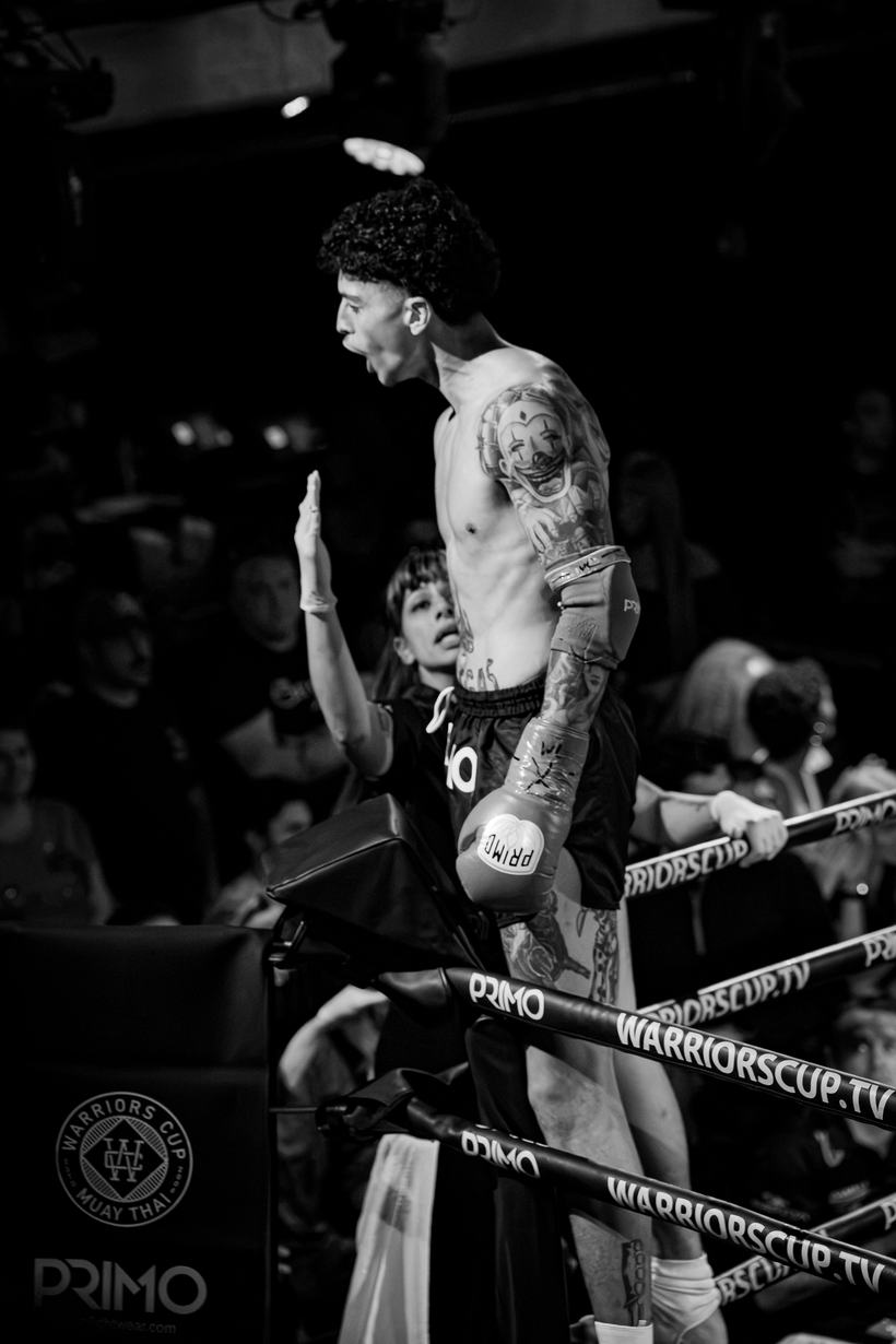 Fighter on the ropes with an arm raised to the crowd