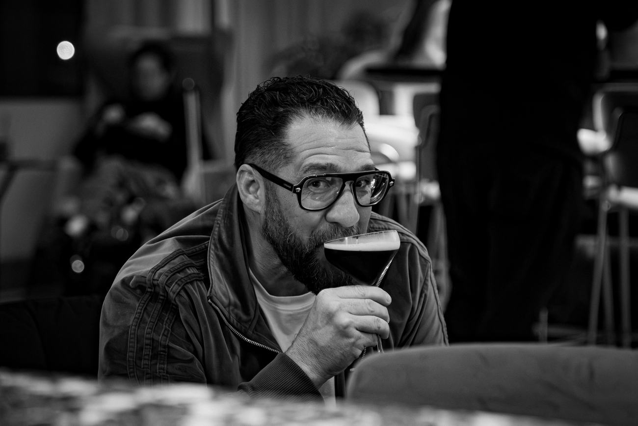 Guest sipping a dark beer between rounds