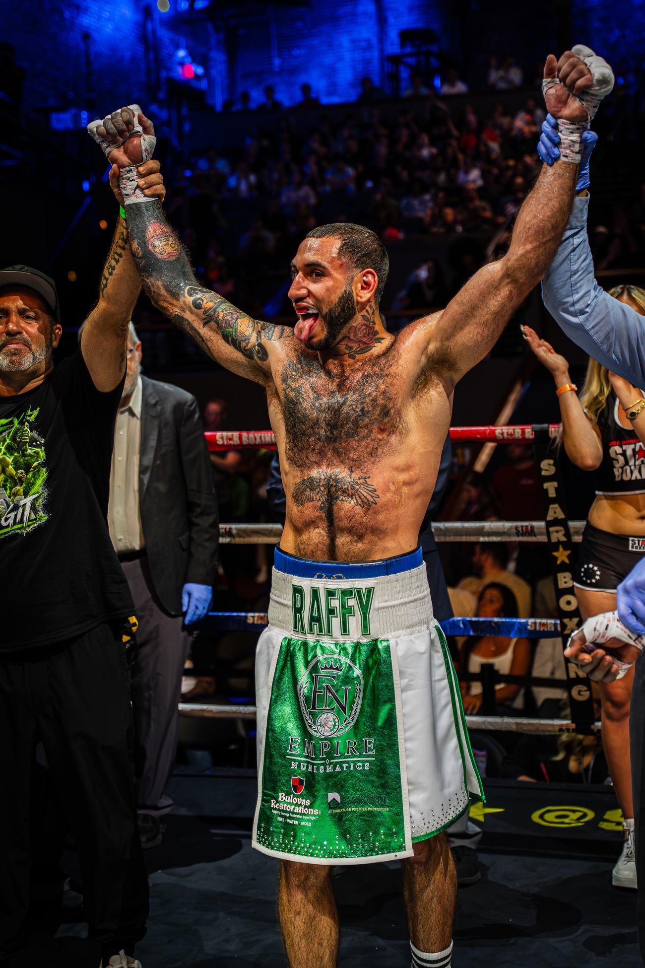 Boxer celebrating with both arms up in the corner