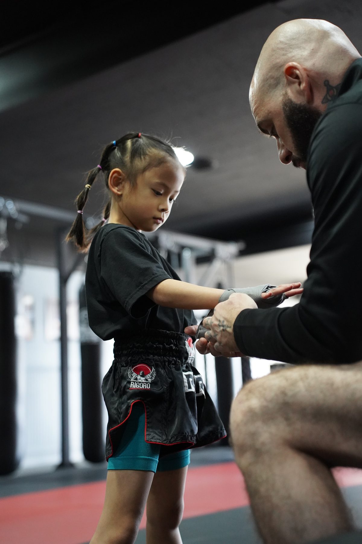 A coach wrapping a young student's hands before class