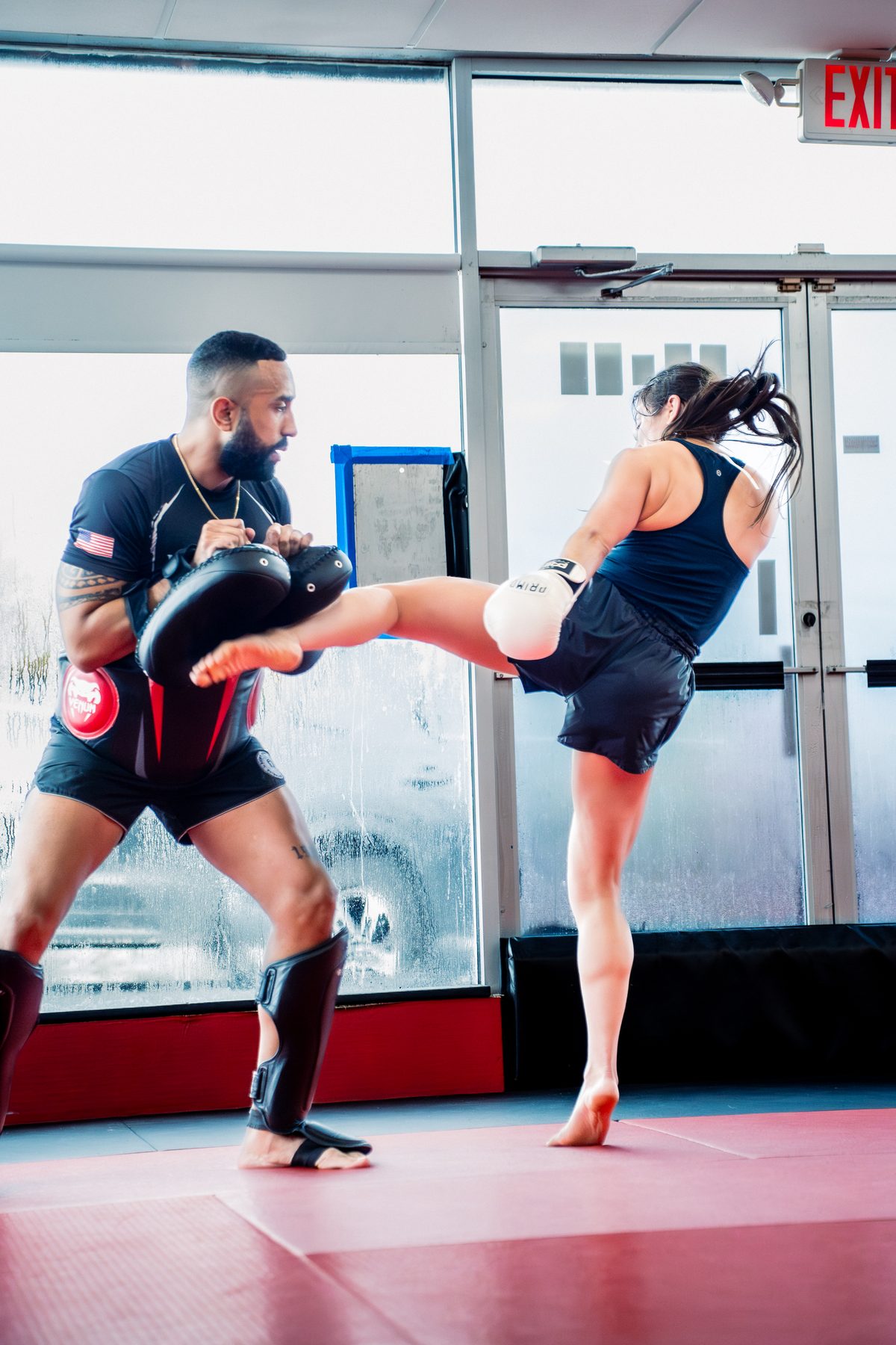 A fighter landing a head kick on the pads