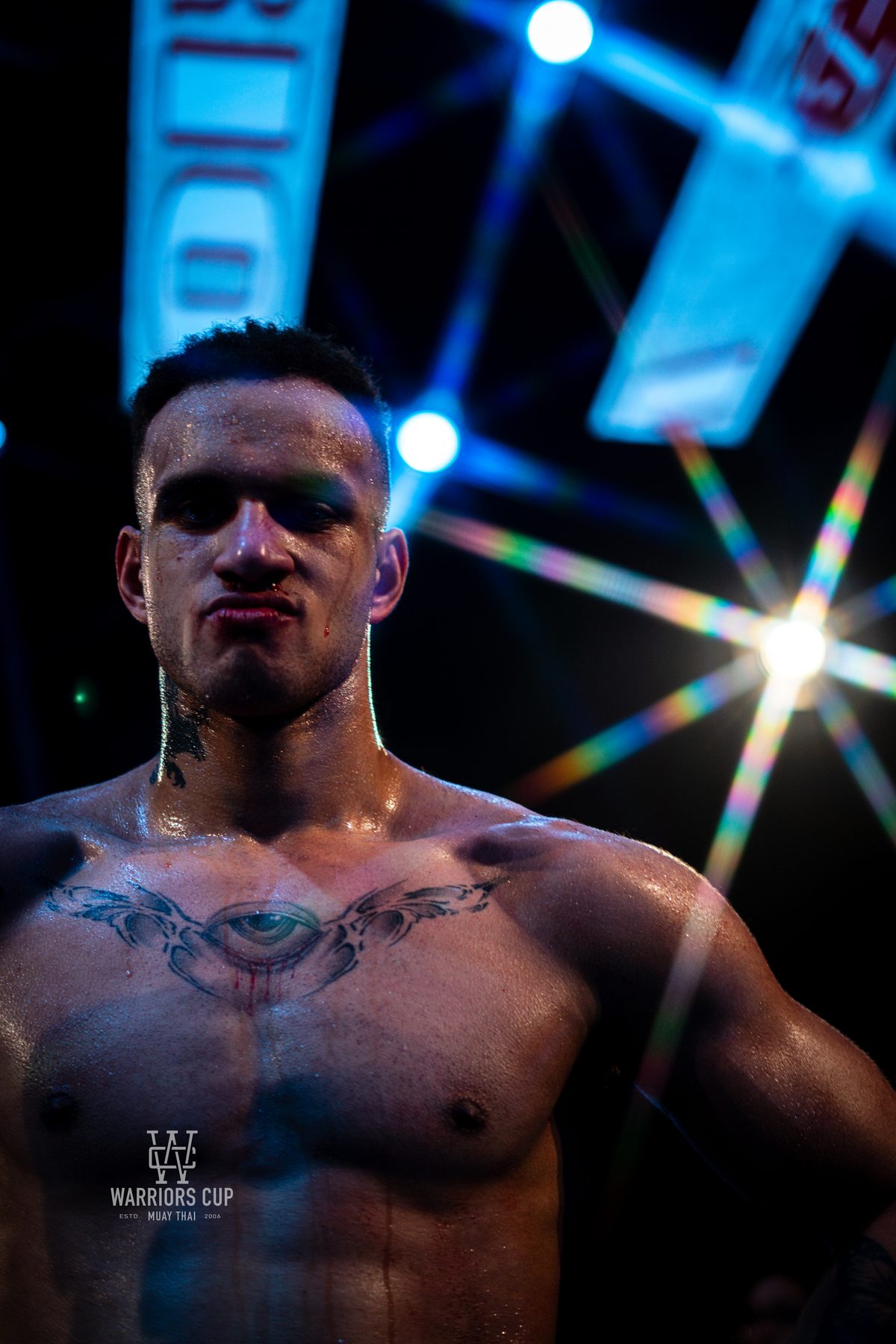 Fighter with arms raised under the ring lights after a win